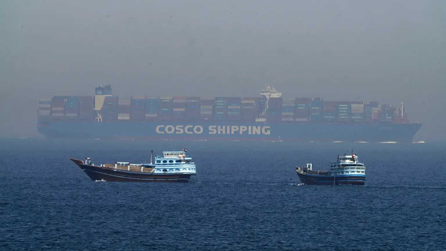 Dos barcos navegan junto a un portacontenedores en Ormuz, el 19 de mayo de 2023