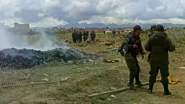 Policías resguardando el dinero que desparramó el avión accidentado.