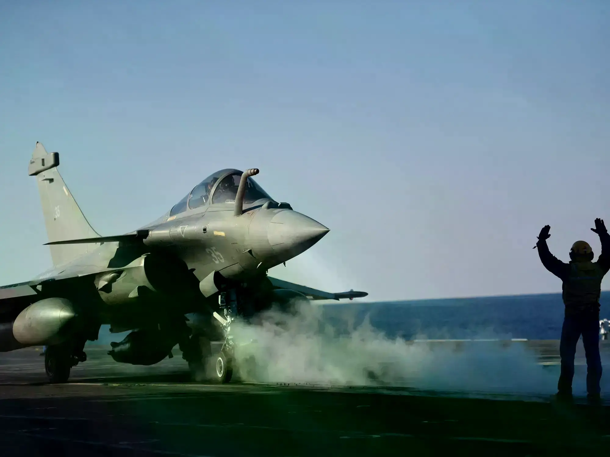 Pantallas transmiten el discurso de Macron sobre la guerra en Irán desde el Palacio del Elíseo.