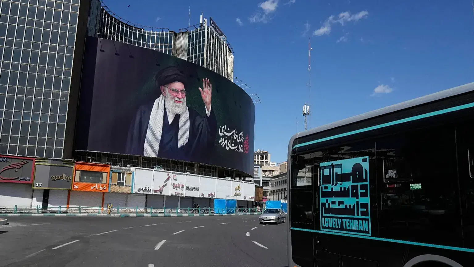 Varios vehículos pasan junto a una valla publicitaria con un retrato del difunto ayatolá Ali Jamenei.