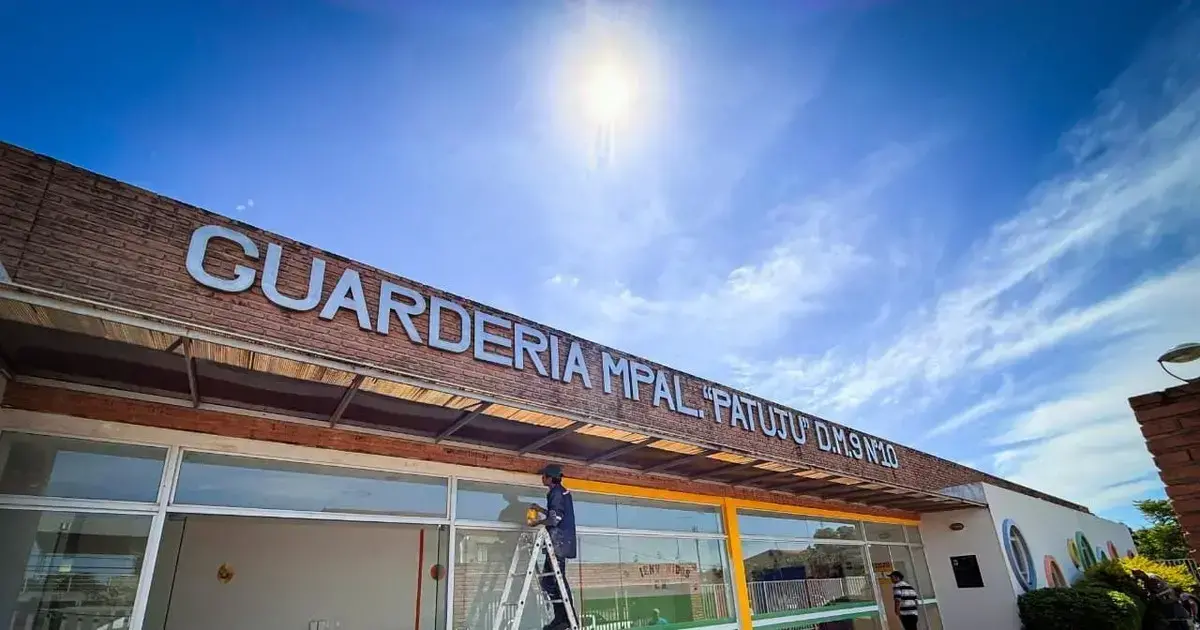 Trabajadores pintan la fachada de una de las guarderías municipales.
