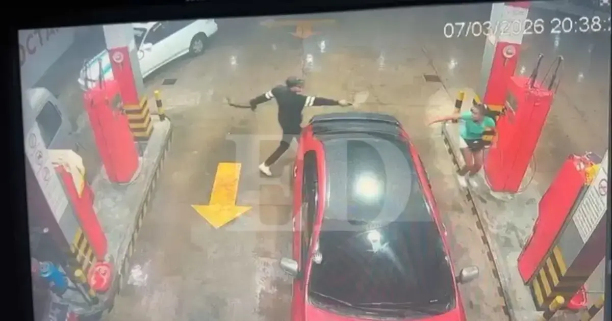 Uno de los antisociales, vestido de negro y con gorra, sigue a la cajera para robar el dinero.