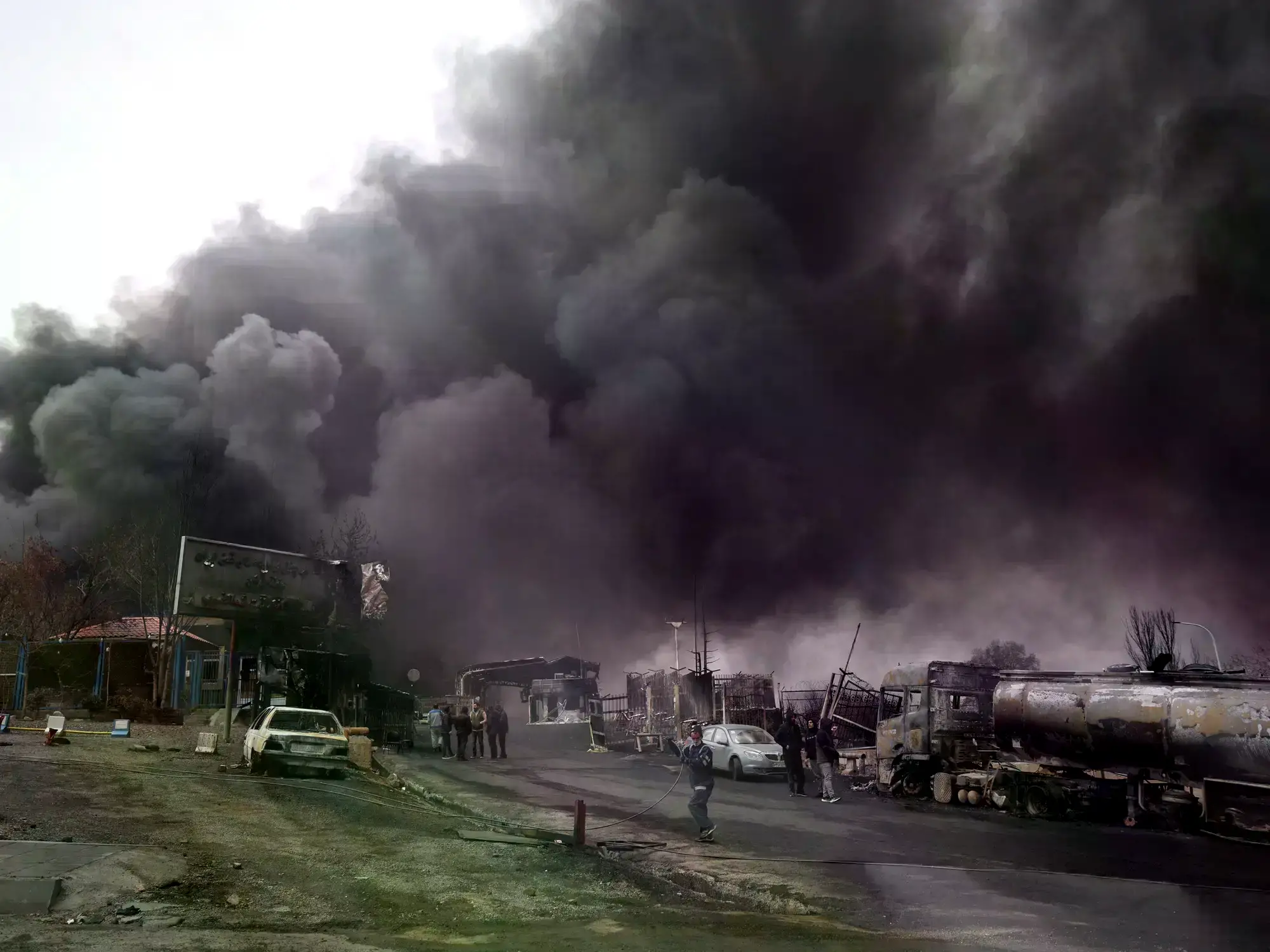Humo se eleva tras un ataque a tanques de combustible en Teherán.