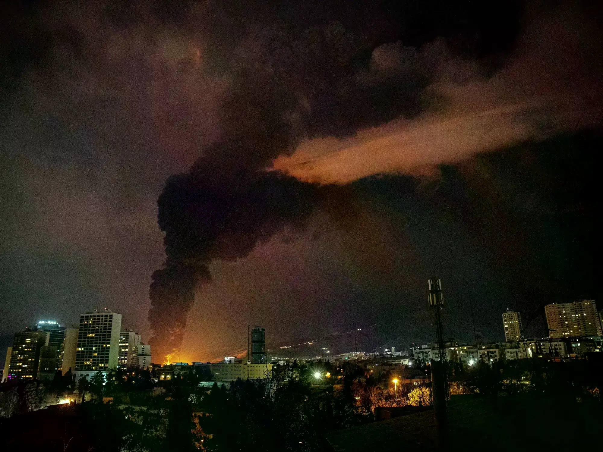 Llamas y humo se elevan desde una instalación de almacenamiento de petróleo atacada en Teherán, Irán.