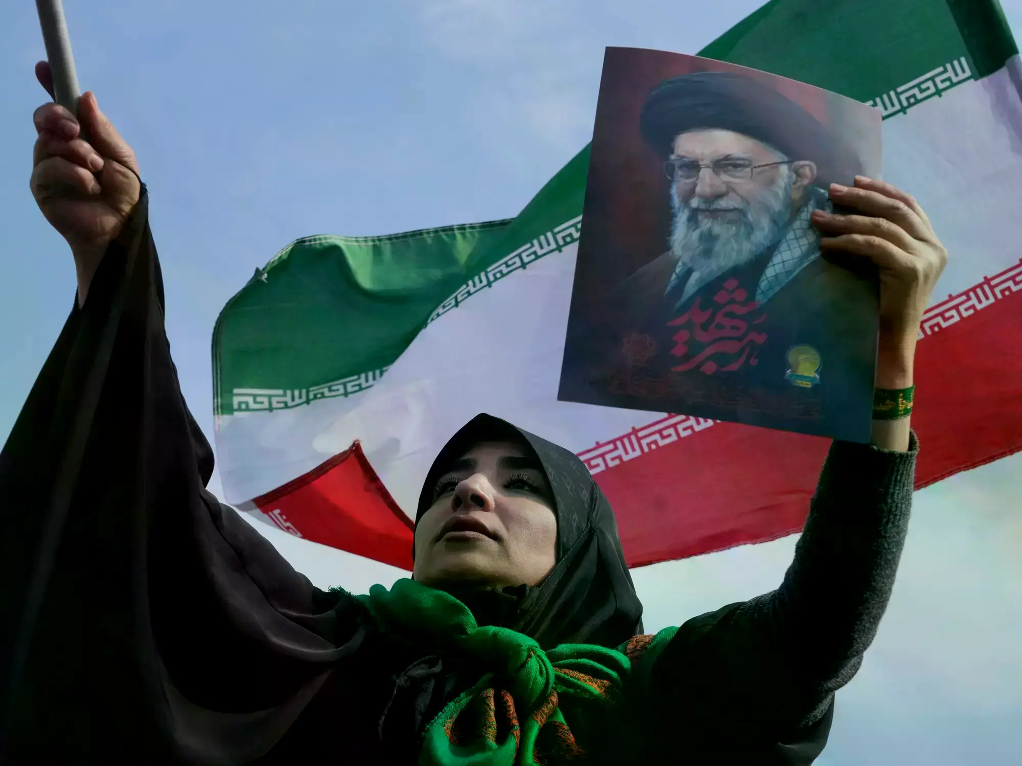 Una mujer iraní muestra una imagen del fallecido ayatolá Ali Khamenei.
