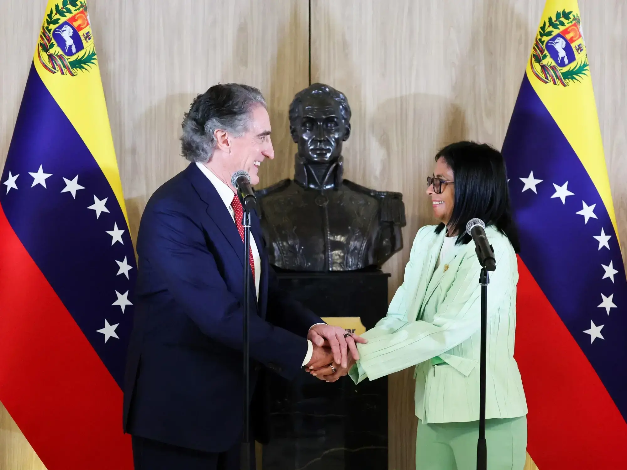 La presidenta encargada venezolana, Delcy Rodríguez, estrechando la mano del secretario del Interior de Estados Unidos, Doug