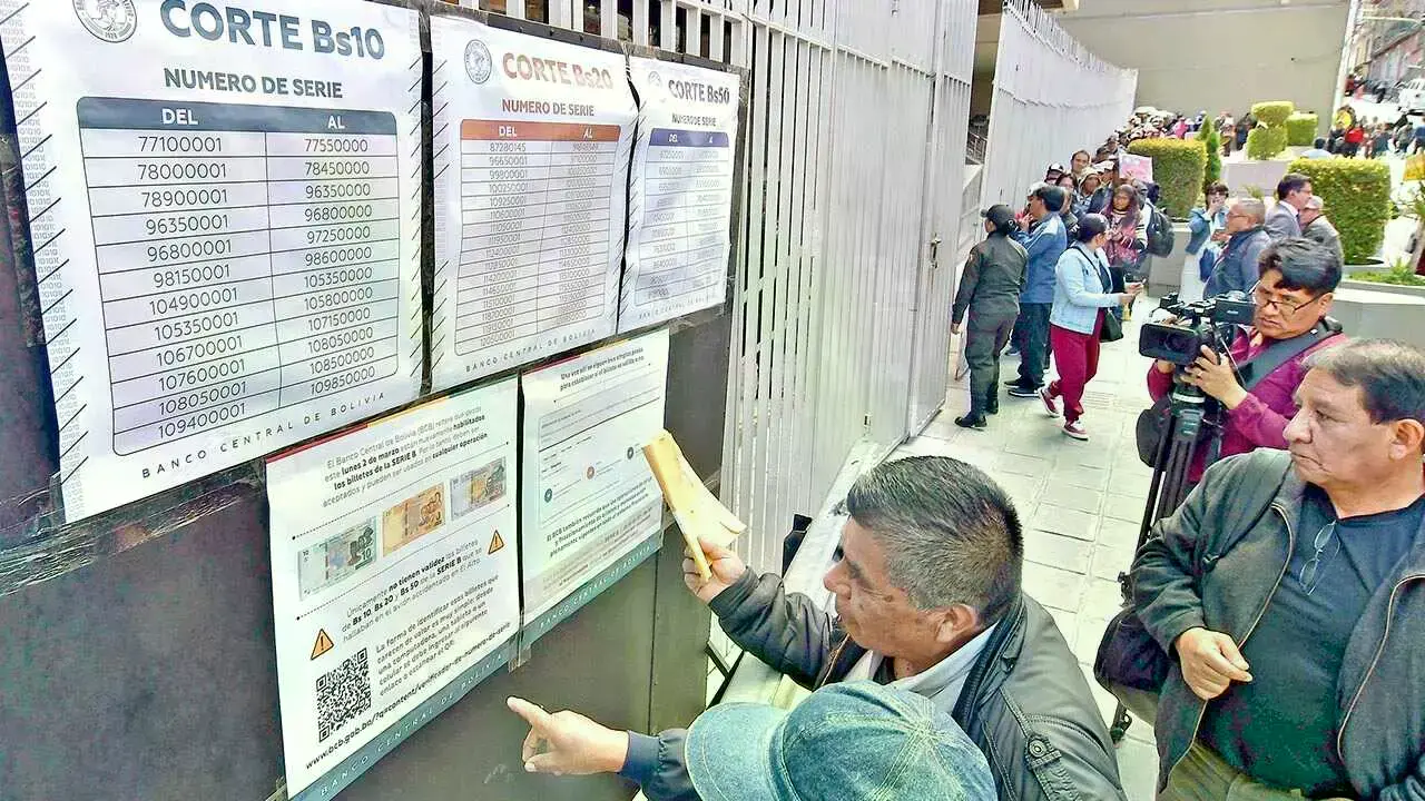 Personas verifican, en puertas del Banco Central, si sus billetes de la Serie B tienen validez.