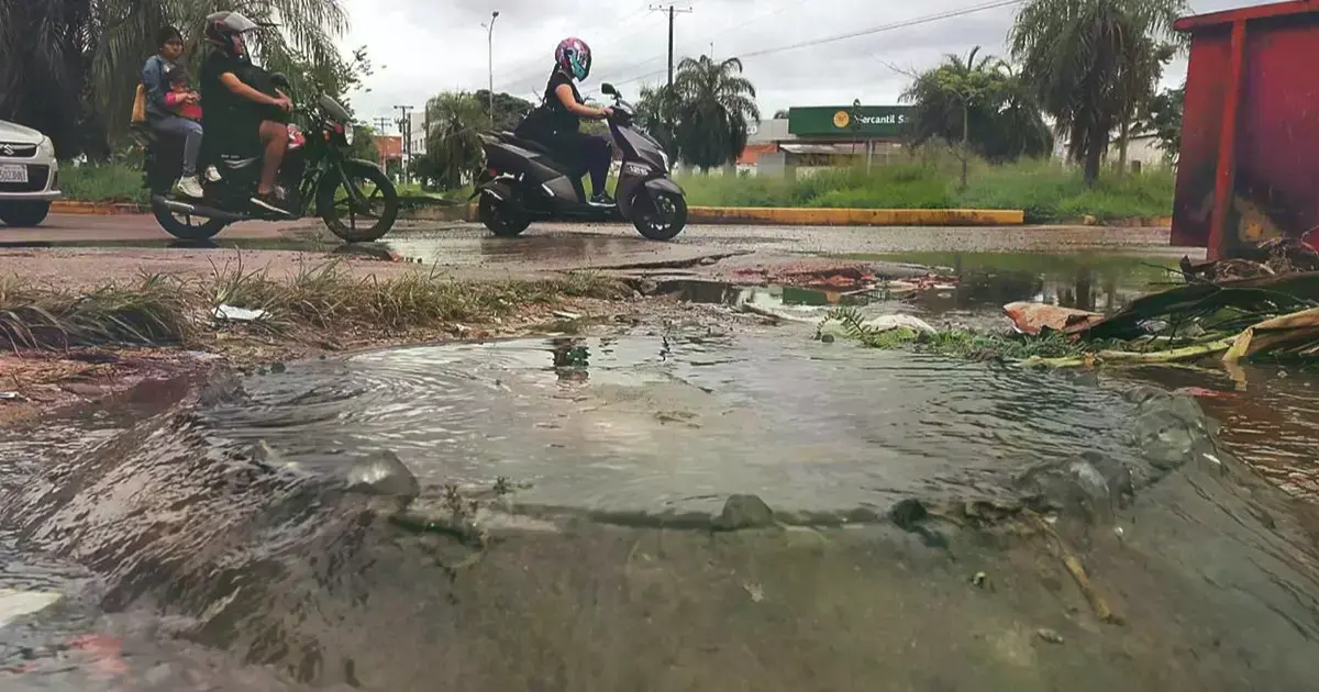 Agua maloliente que rebalsa de una alcantarilla se mezcla con agua de lluvia en una vía.