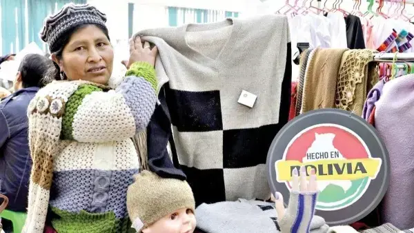 Una microempresaria muestra una prenda de vestir.