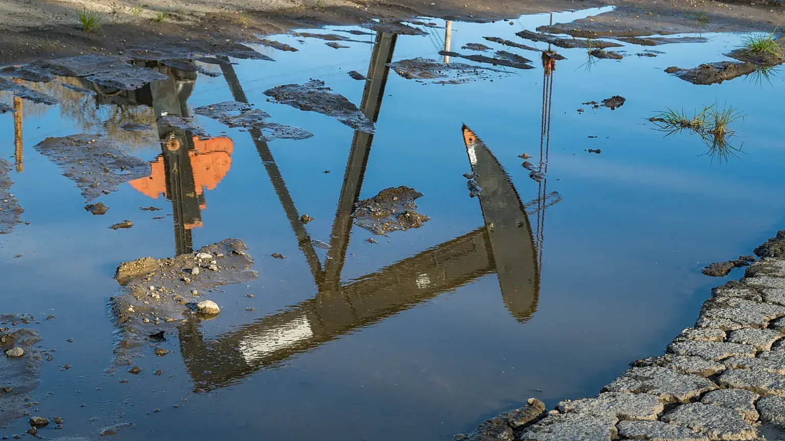 Un pozo se refleja en un charco en el campo petrolífero de San Ardo, California.