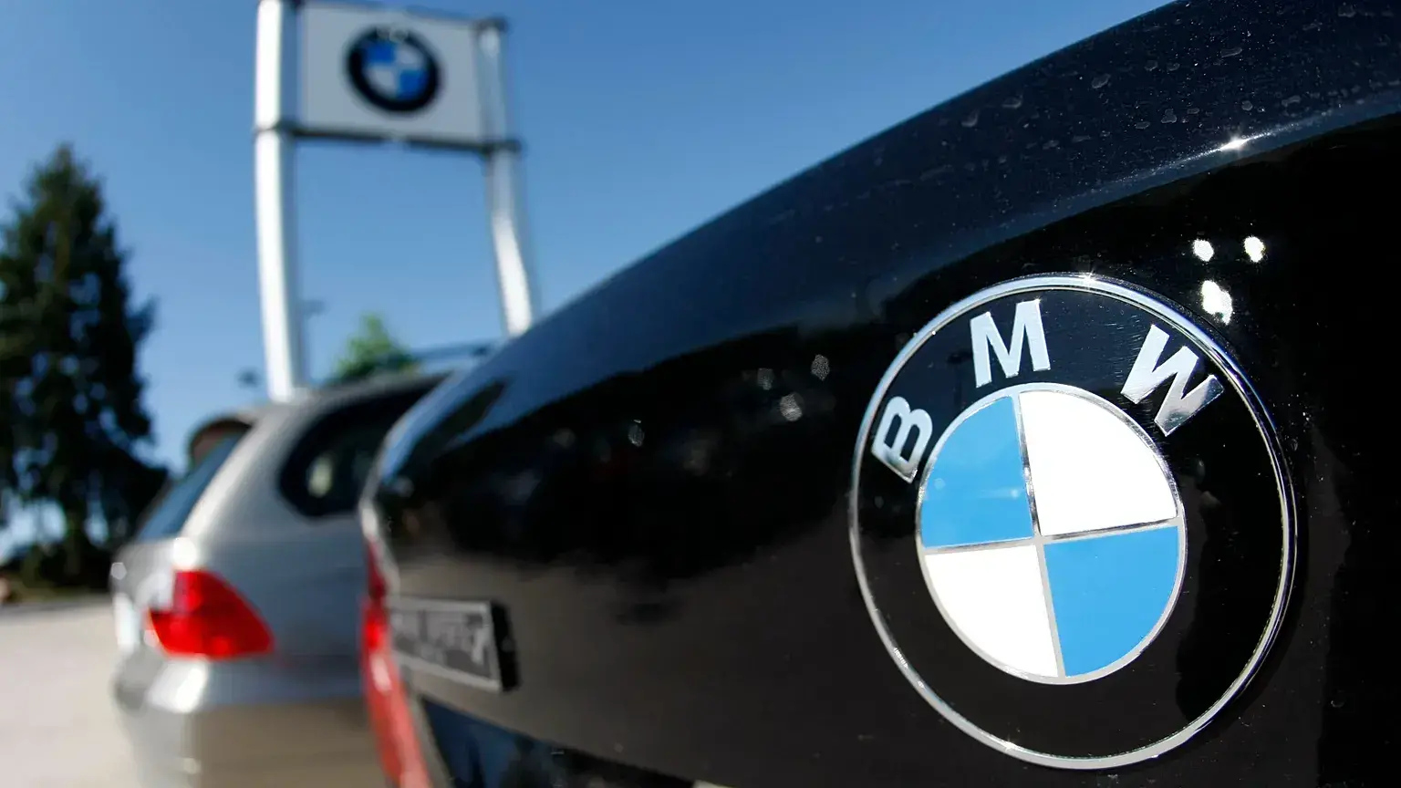Logotipo de BMW en el capó de un vehículo en un concesionario.