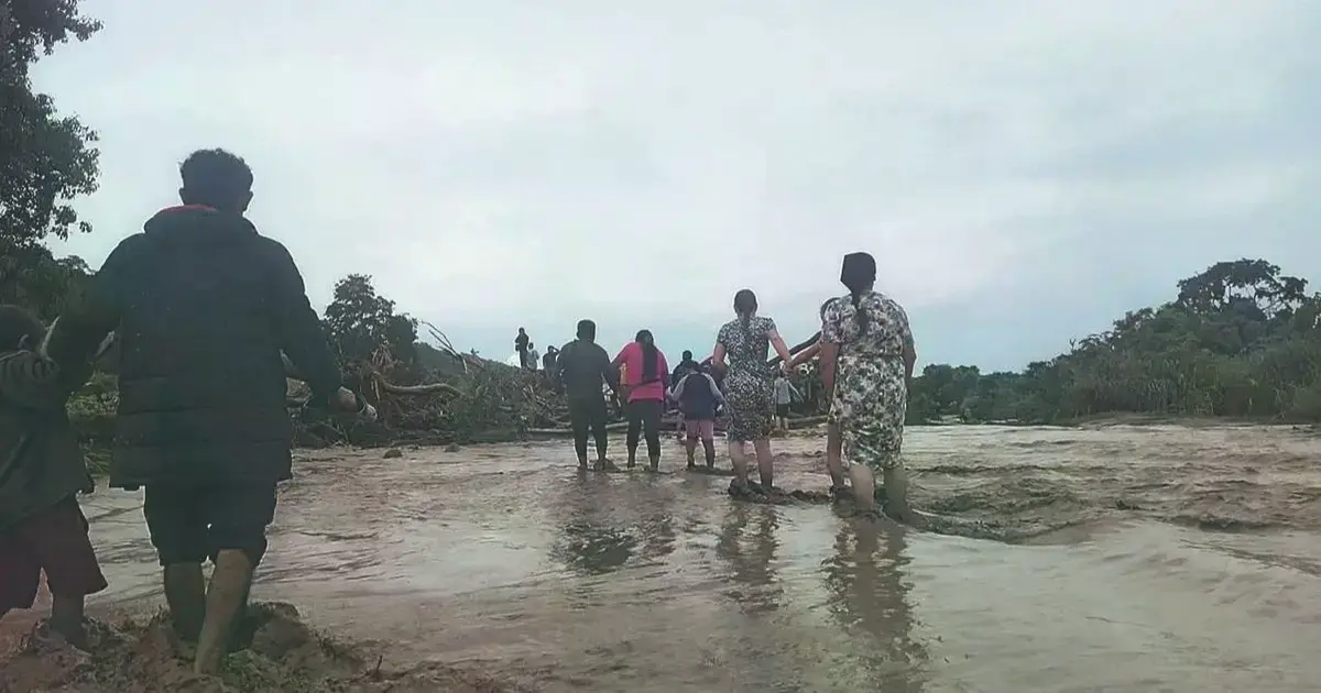 Comunarios caminan entre el lodo para evacuar a lugares seguros tras el desborde de quebradas.