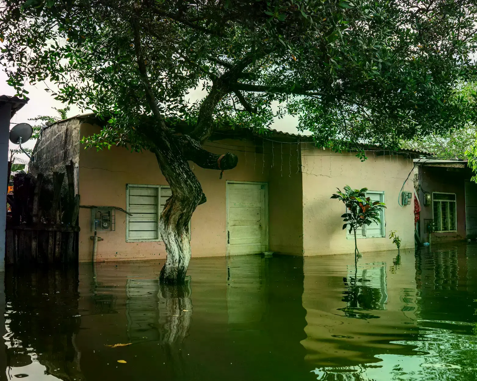 Dos jóvenes intentan usar un refrigerador como canoa improvisada en el barrio La Palma, Montería.