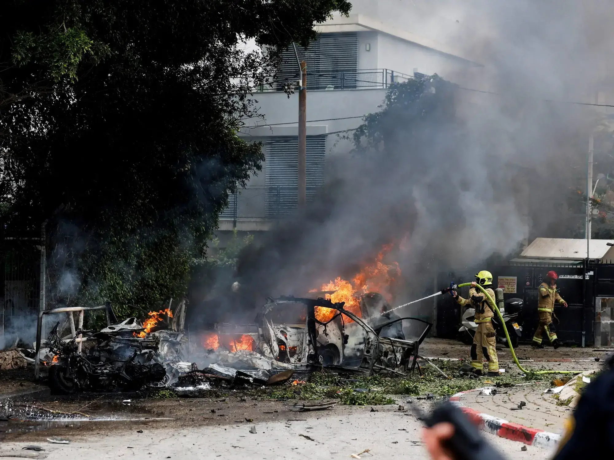 Un bombero apaga el fuego tras el impacto de un misil lanzado por Irán en territorio de Israel.
