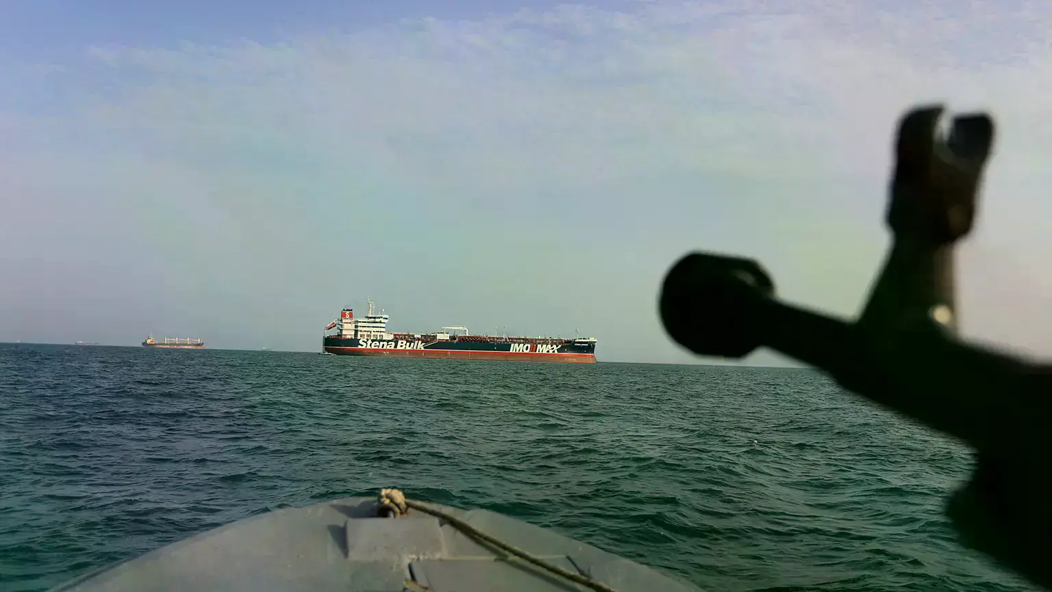 Lancha de la Guardia Revolucionaria iraní apunta arma al petrolero británico Stena Impero, retenido en el estrecho de Ormuz.