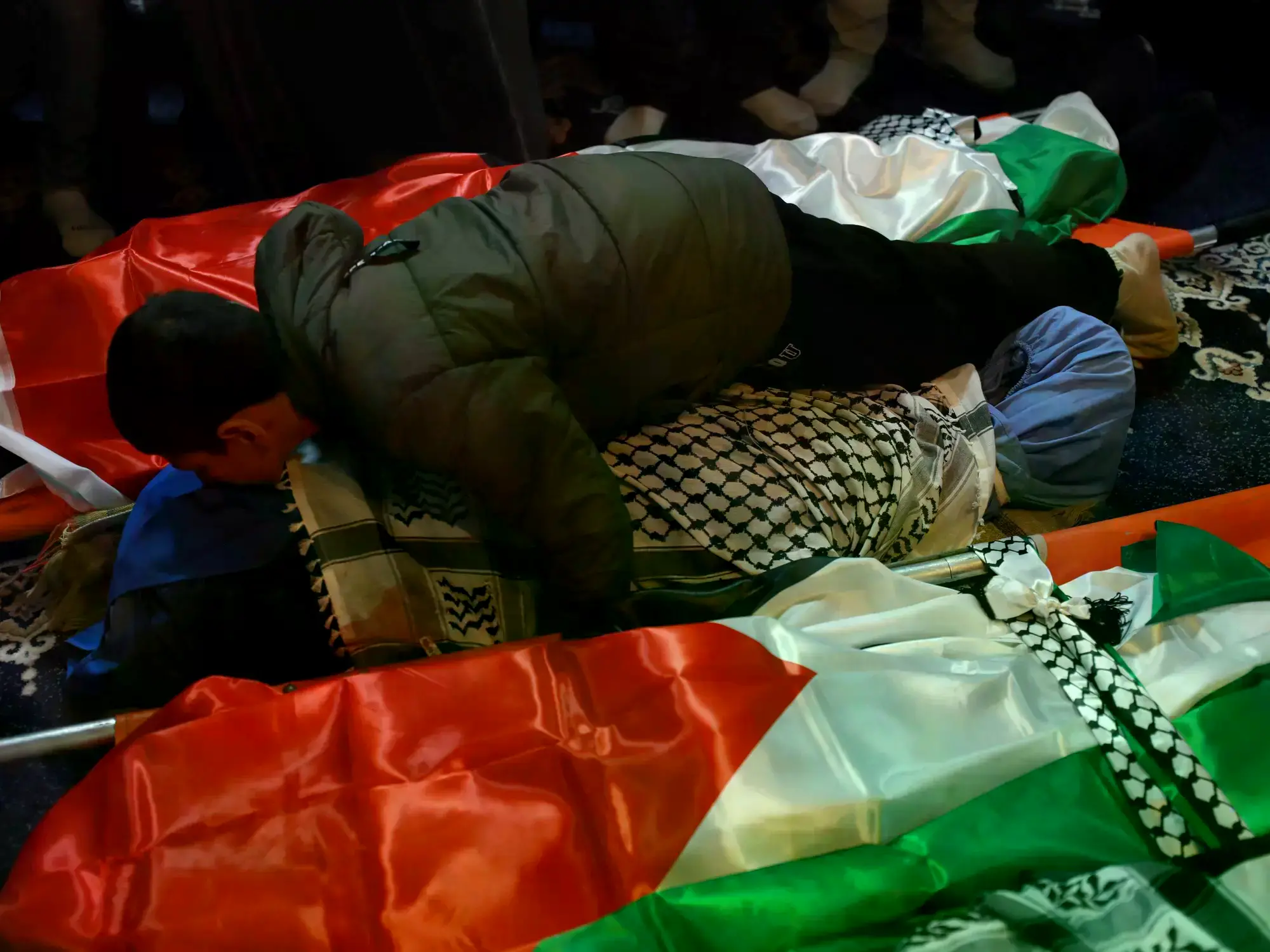 Un niño palestino besa el cuerpo de una víctima en un funeral en Tammun, Cisjordania.