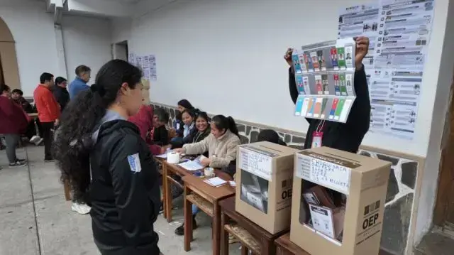 Un jurado electoral muestra la papeleta de votación.