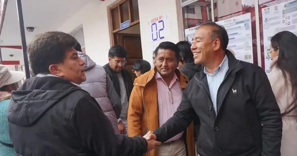 Andrés Gómez saluda a una persona en un recinto de votación de La Paz.