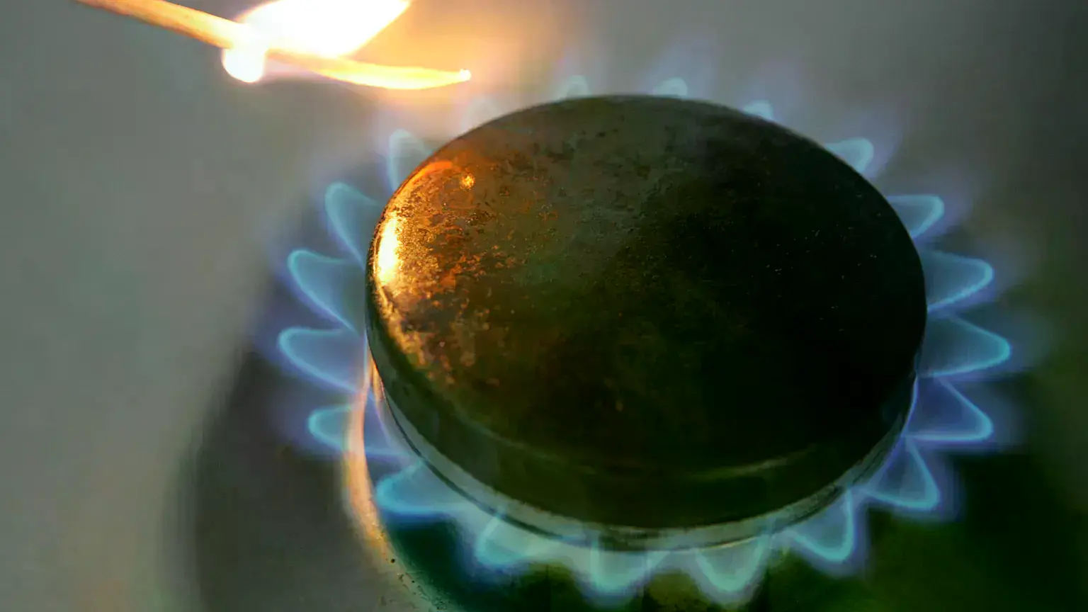 Una llama de un fogón se enciende en una cocina.