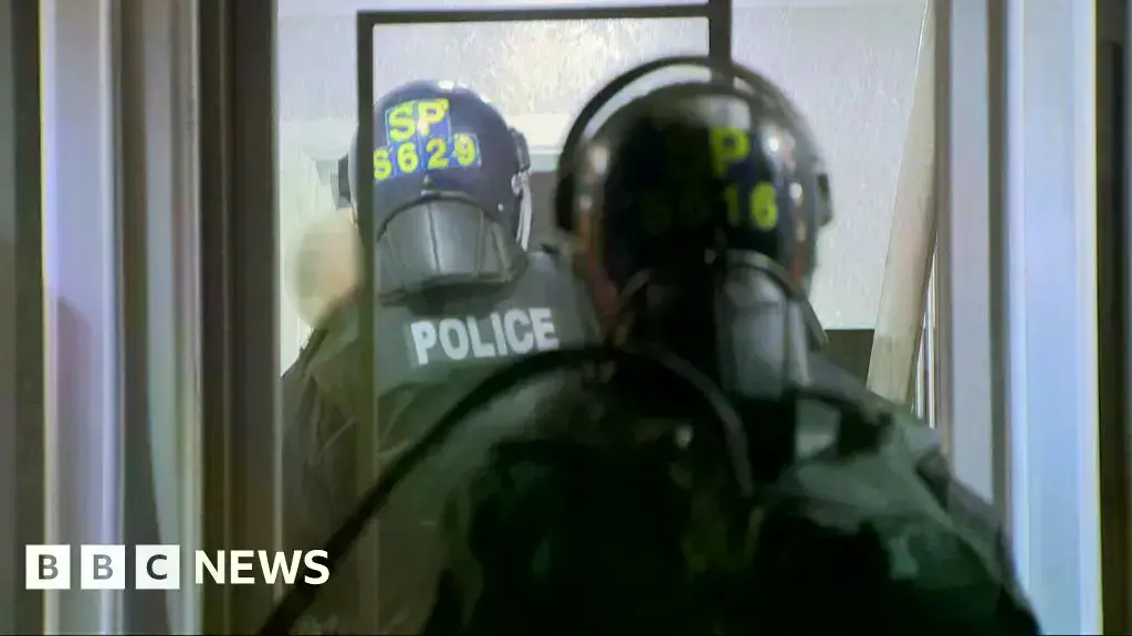 Un convoy de vehículos policiales se prepara para una redada en las calles de Lanarkshire antes del amanecer.