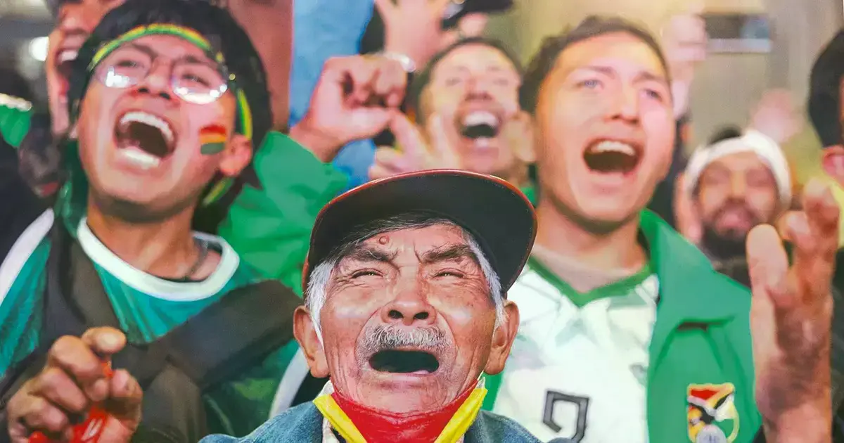 Hinchas bolivianos celebran la victoria de su selección en las calles.
