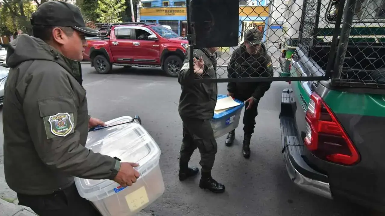 Policías trasladan el material colectado en la casa de Luis Arce.