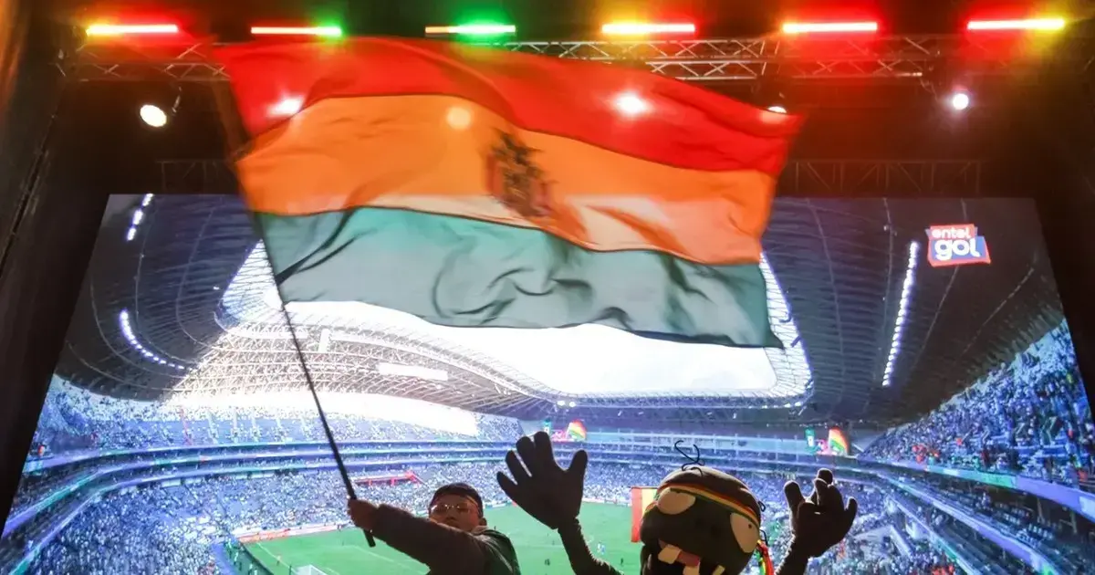 La bandera boliviana flamea en el estadio Gigante de Acero, junto a dos hinchas.