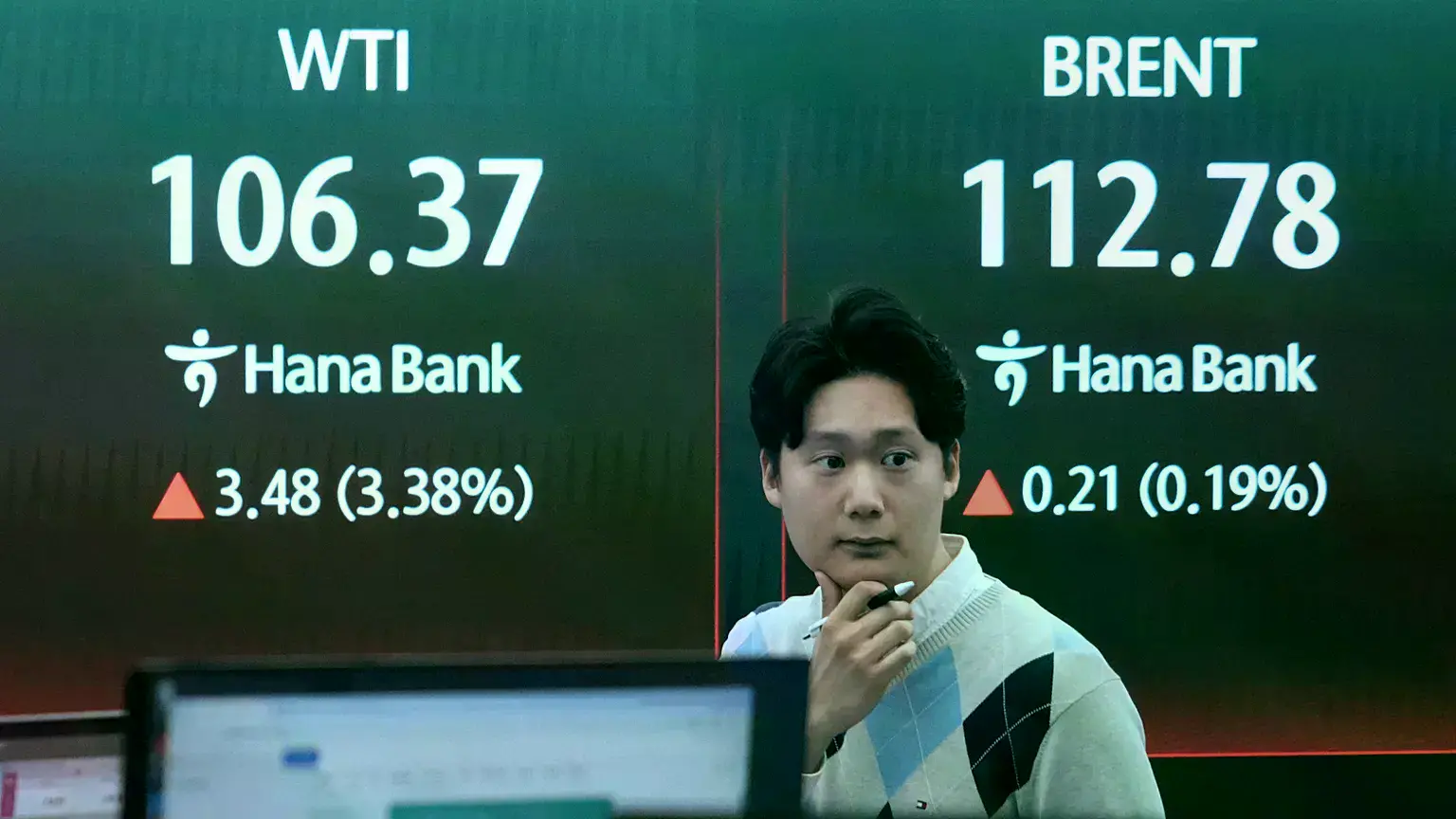 Un operador de divisas reacciona cerca de una pantalla que muestra los precios internacionales del petróleo en Seúl, Corea de