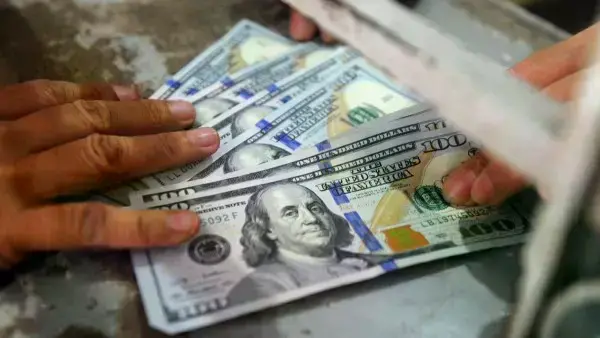 Imagen ilustrativa de monedas y gráficos económicos.