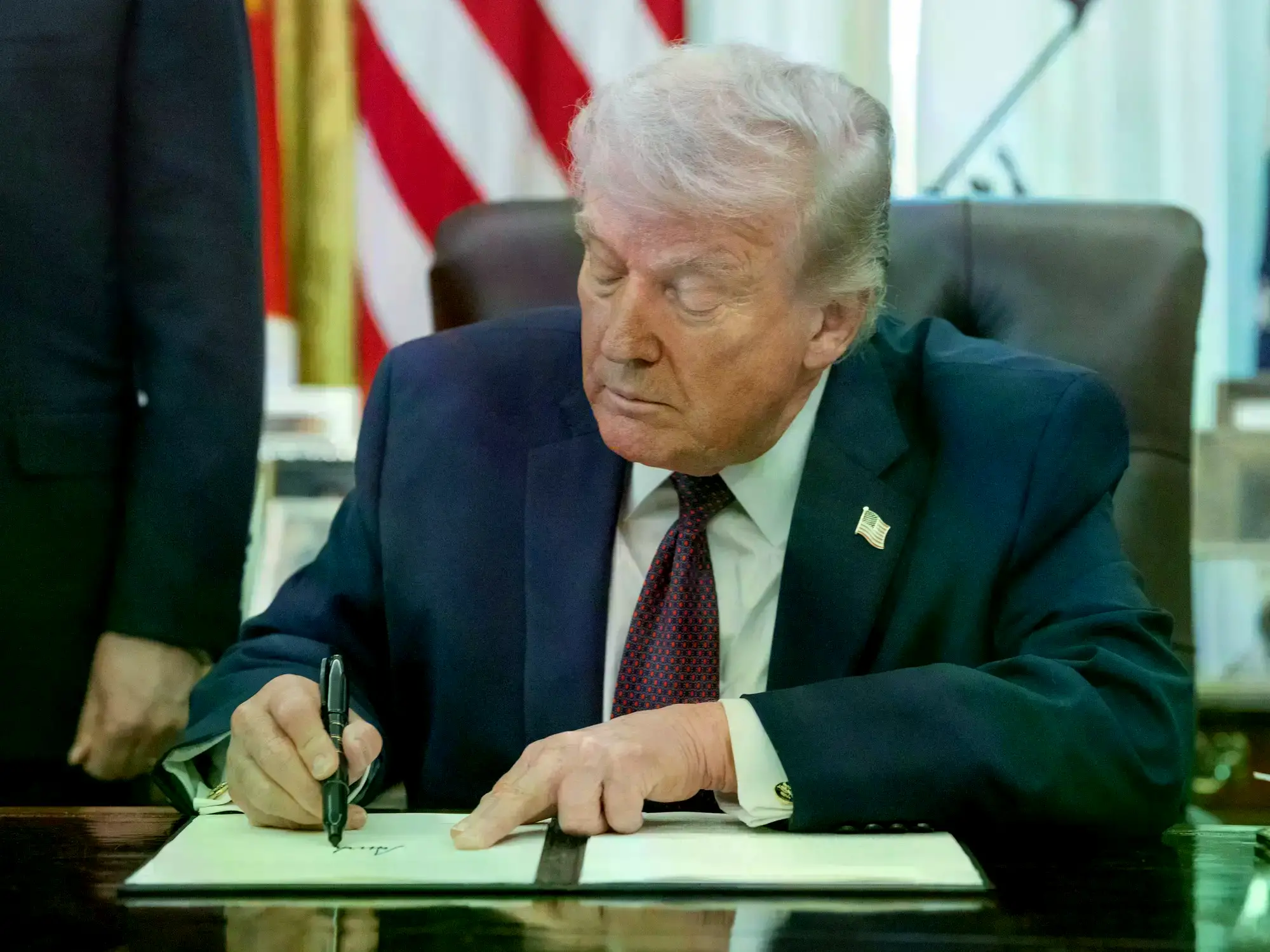Trump firma un decreto en la oficina Oval.