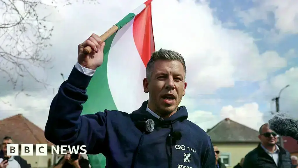 Un partidario de Magyar sostiene una pancarta con su eslogan 'Ahora'.