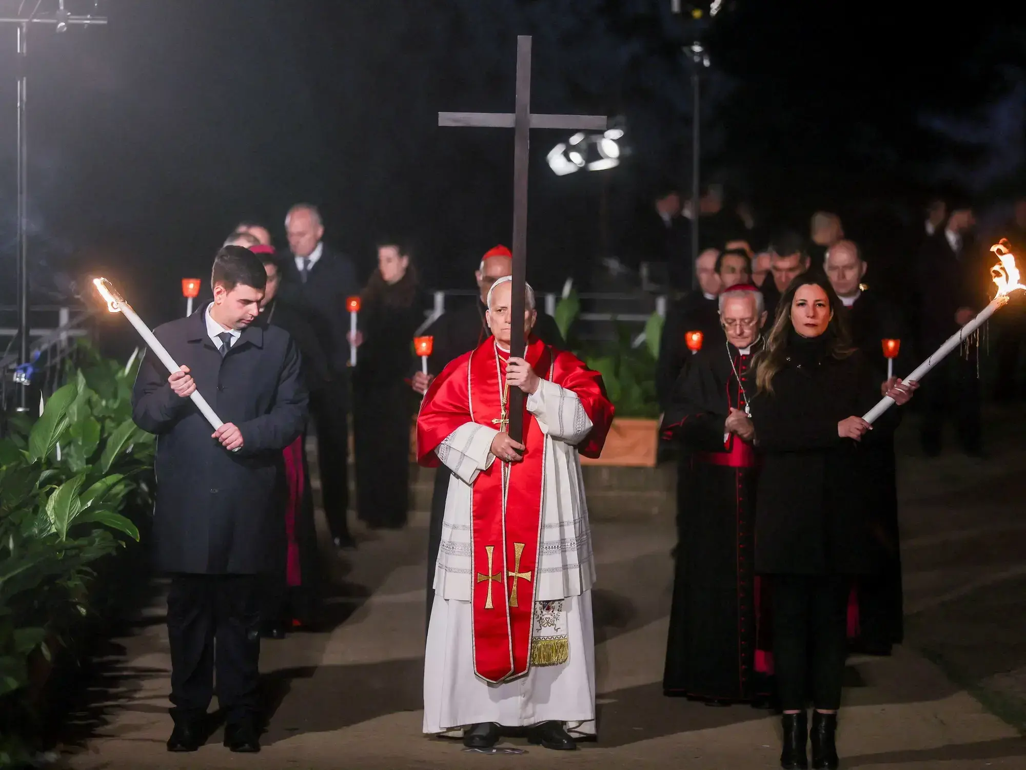 El Papa León XIV lleva la cruz mientras encabeza el Via Crucis en el Coliseo de Roma.