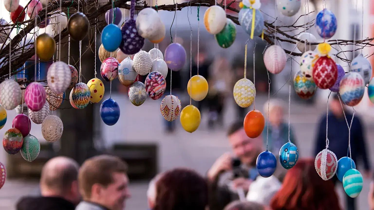 Visitantes fotografían un árbol decorado con más de 10.000 huevos de Pascua pintados en Saalfeld, Alemania.
