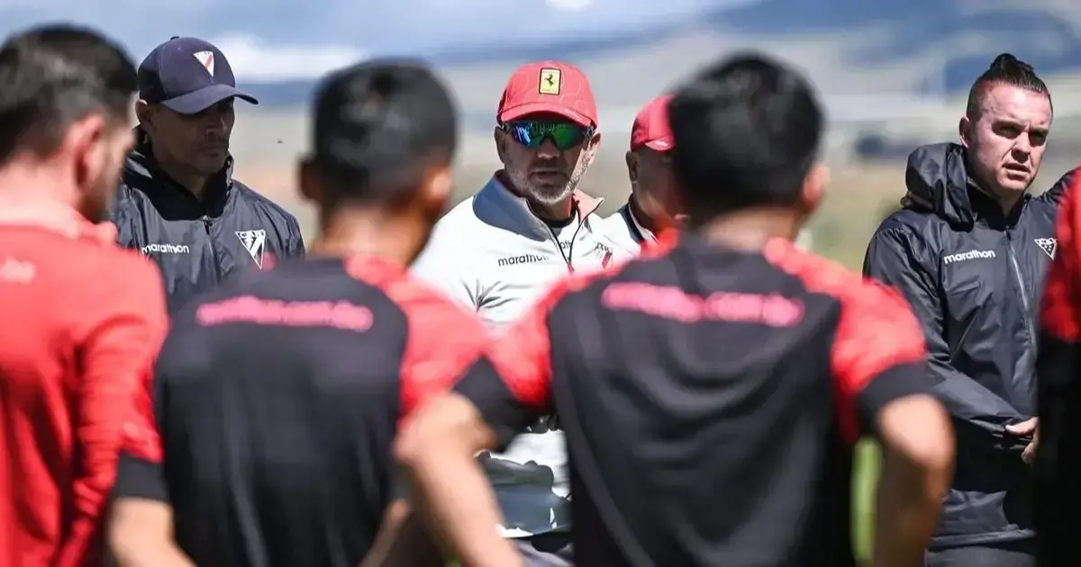 Julio Baldivieso (con gorra roja) da instrucciones a sus dirigidos de la banda roja.