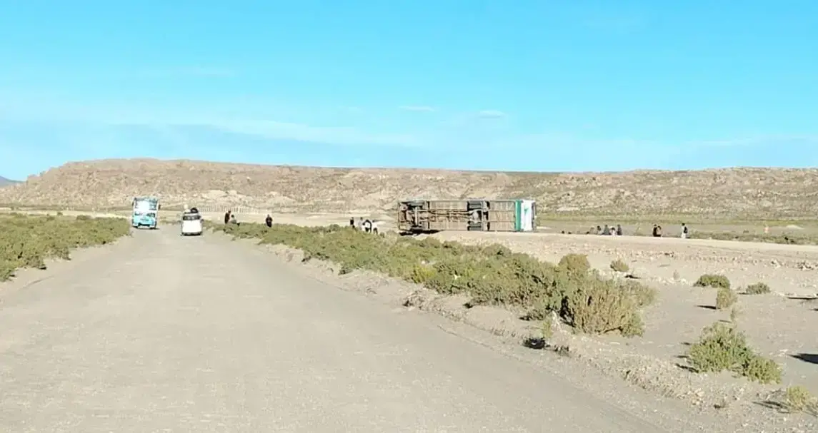 Bus volcado en medio de la carretera tras el accidente.