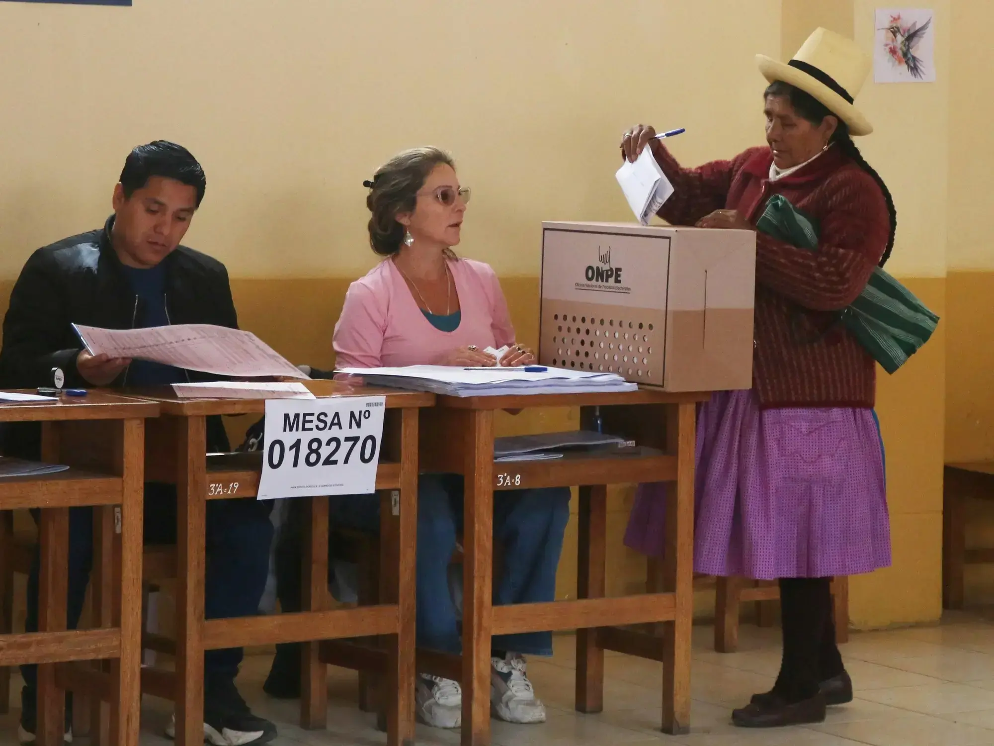 Una mujer deposita su voto en Urumbamba, Cusco, Perú.