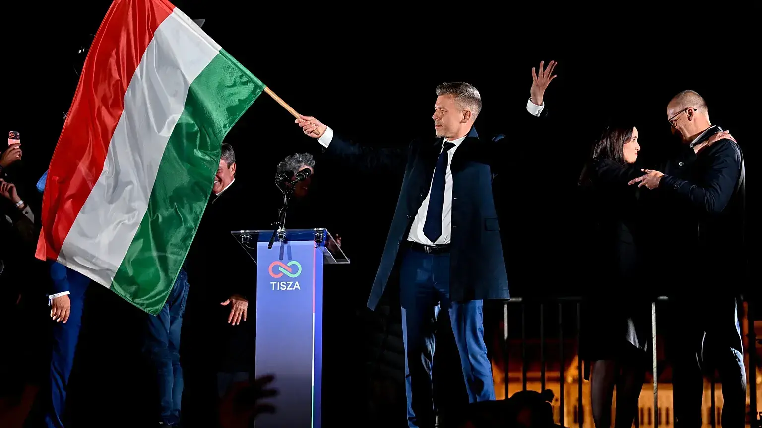 Péter Magyar, líder del partido Tisza, agita la bandera húngara tras los resultados electorales.