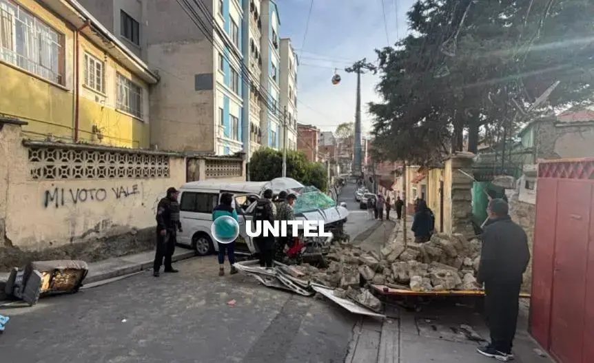 Minibús impactado contra la fachada de una vivienda.