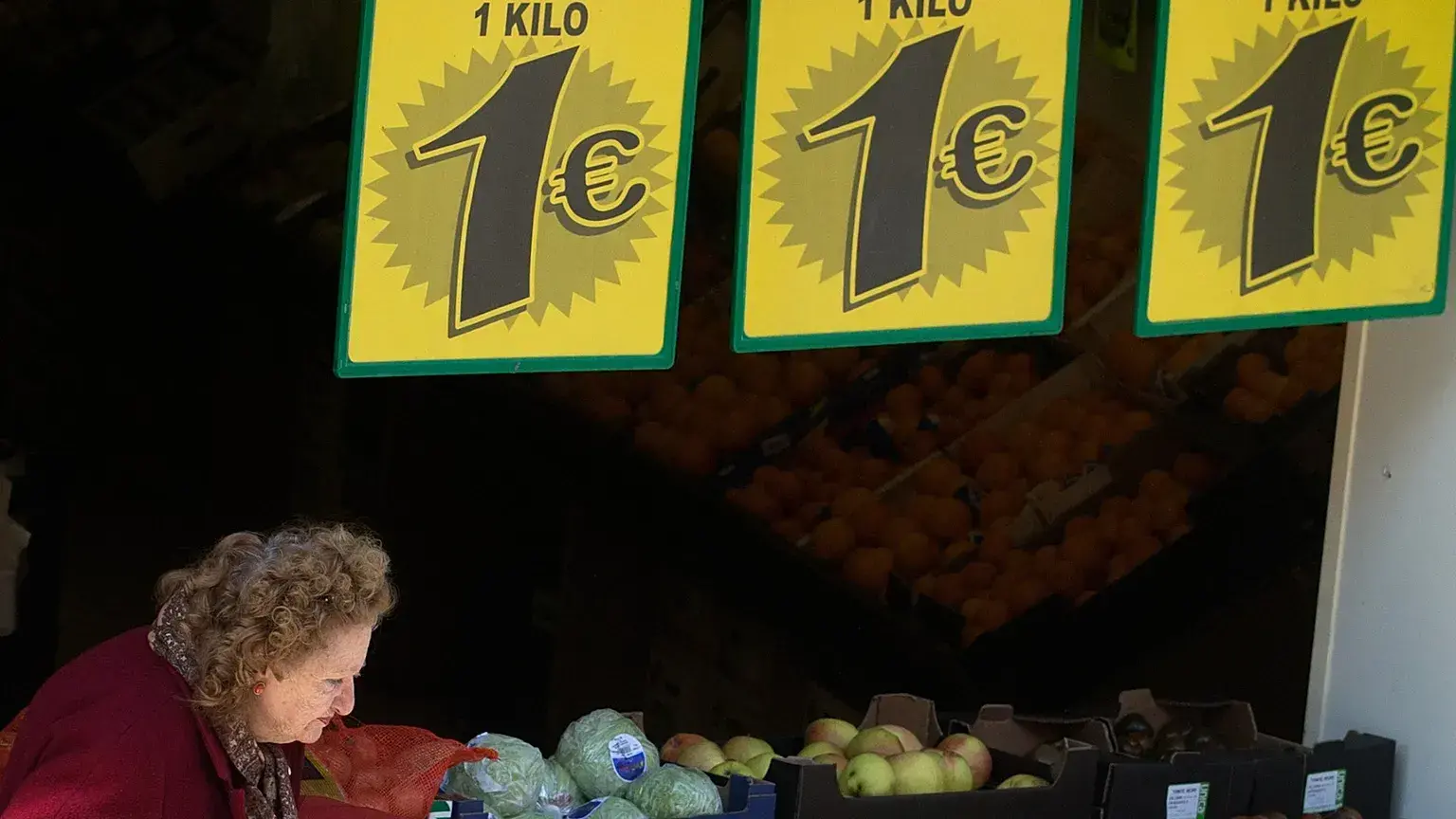 Una clienta sale de una frutería con ofertas especiales en Madrid, el 20 de marzo de 2013.