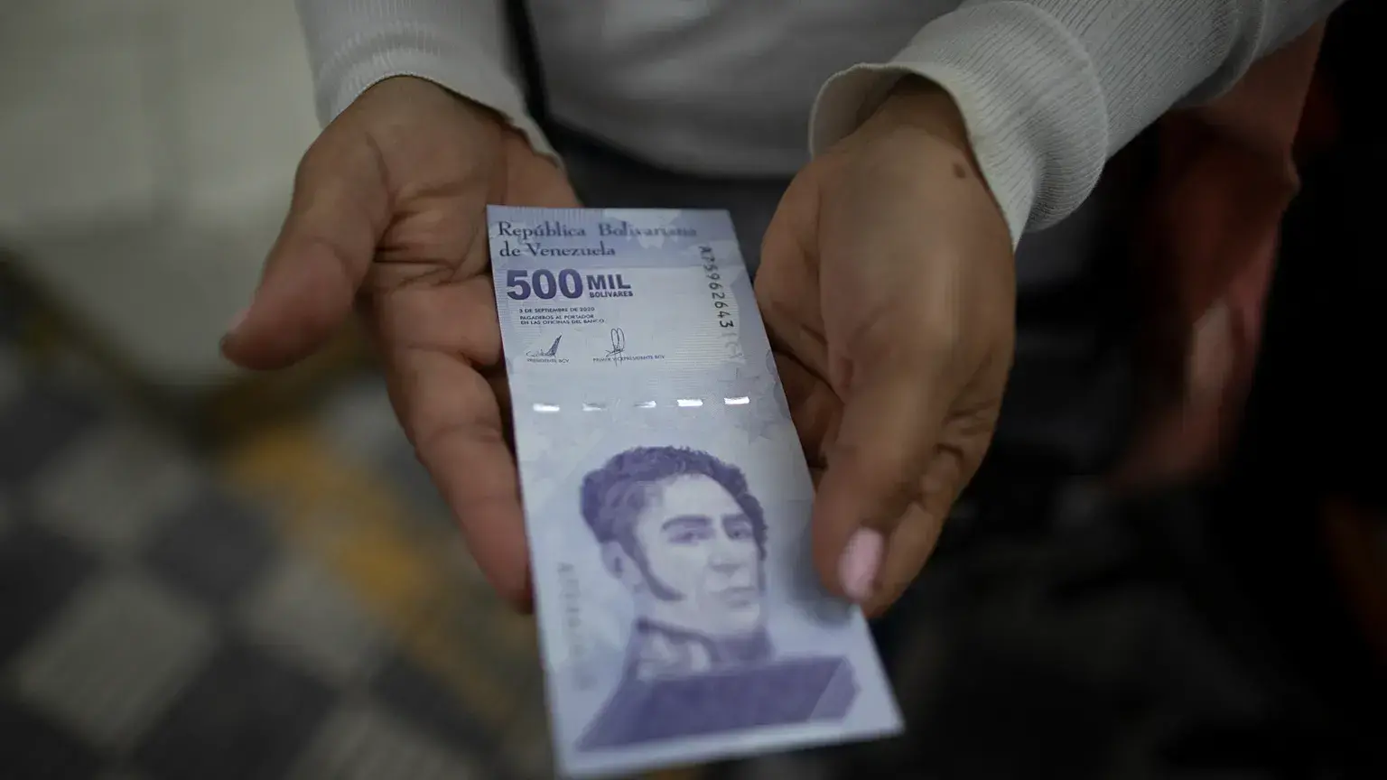 Una mujer muestra un nuevo billete de 500.000 bolívares en un banco de Caracas en marzo de 2021.