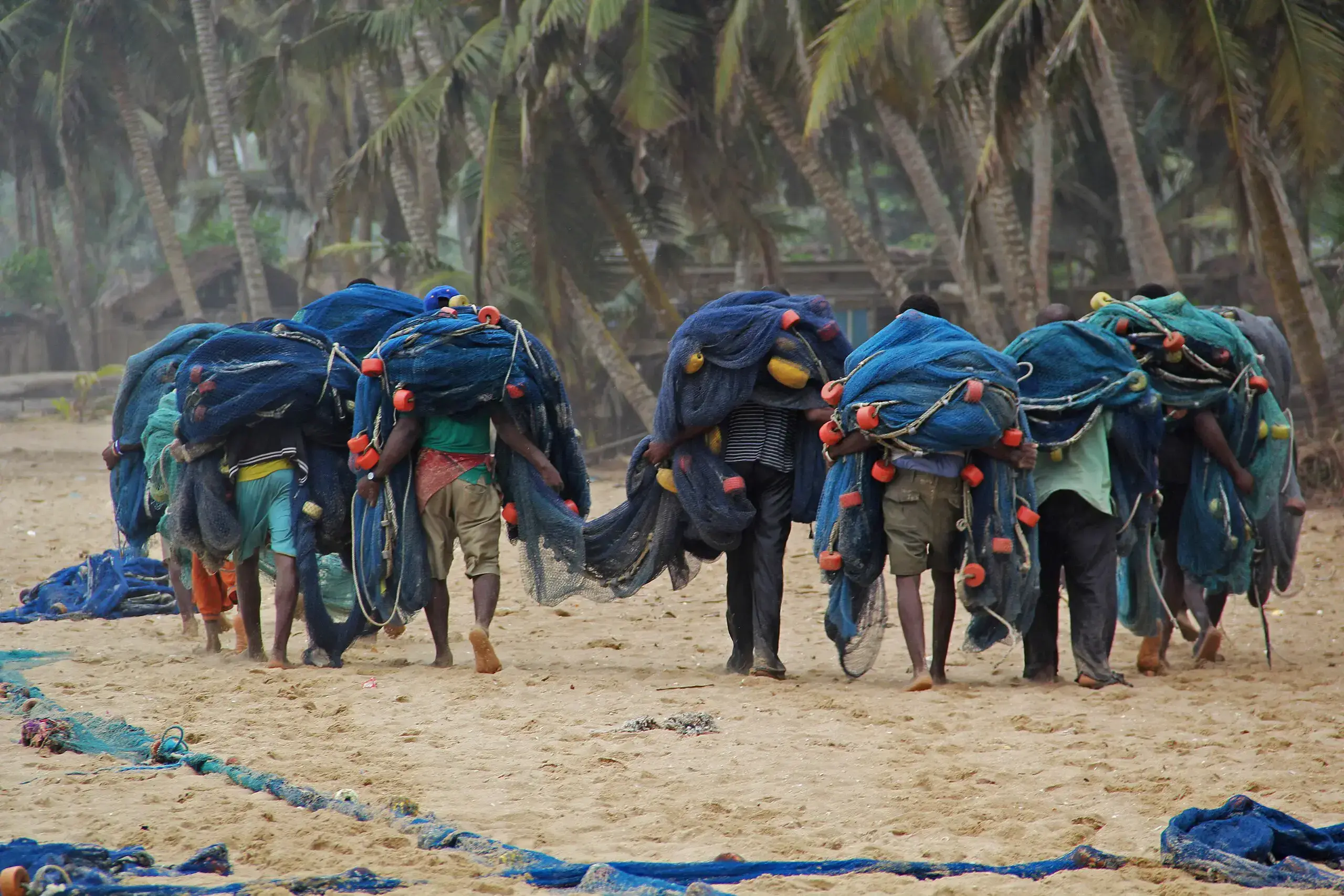 Pescadores en Ghana cargan sus redes en la playa.