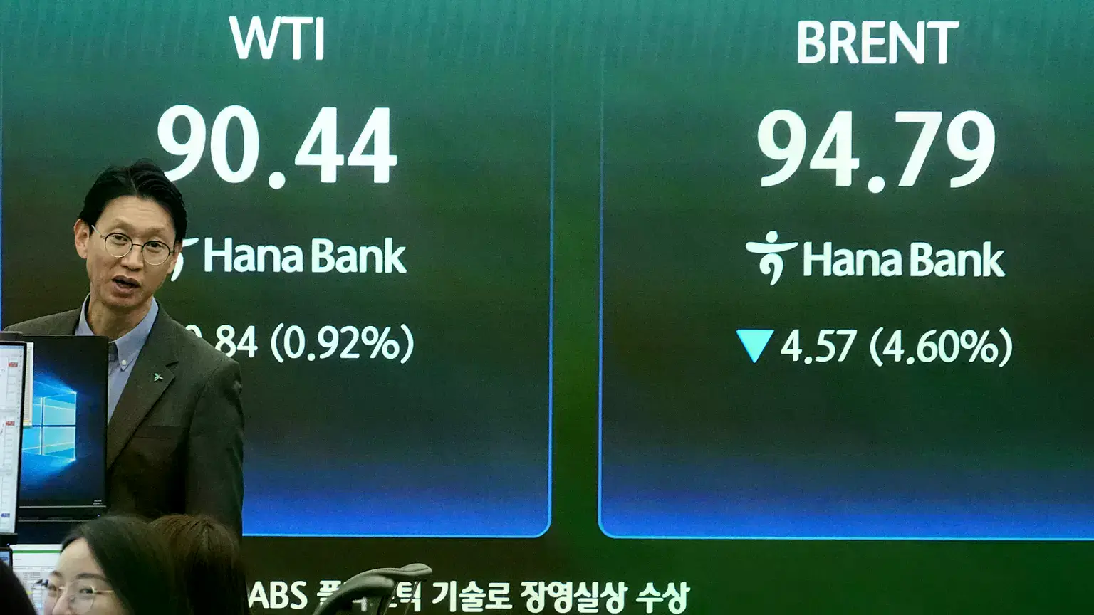 Un operador de divisas reacciona junto a una pantalla con los precios internacionales del petróleo en la sede del Hana Bank e