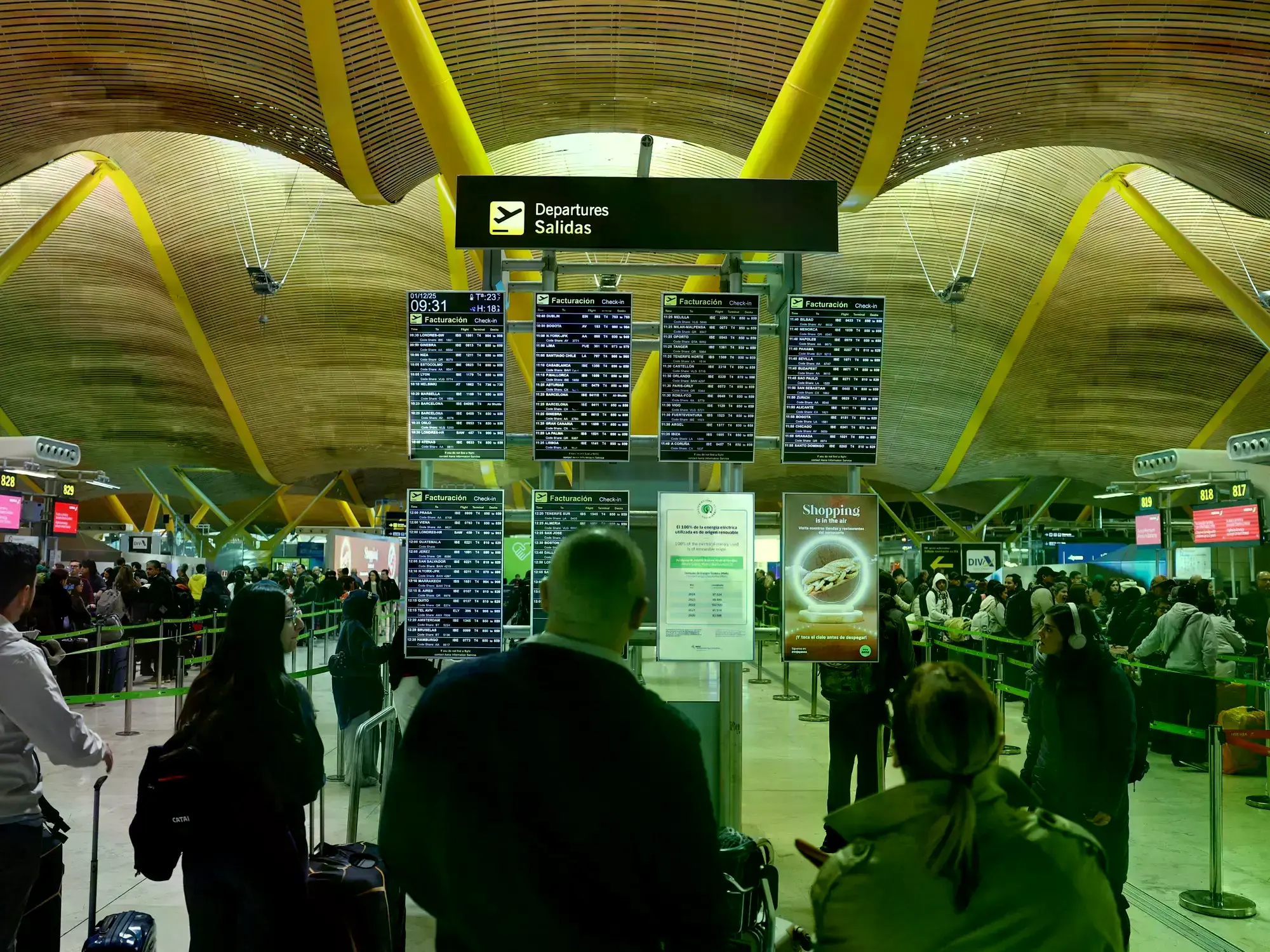 Un grupo de viajeros revisa los horarios de sus aviones en la terminal 4 del aeropuerto de Madrid Barajas.