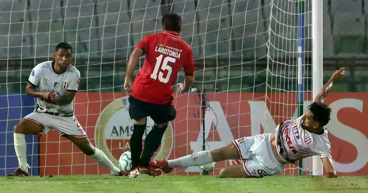 Larotonda, de Caracas FC, remata ante la oposición de Luis Palma y Saúl Torres, de Independiente.