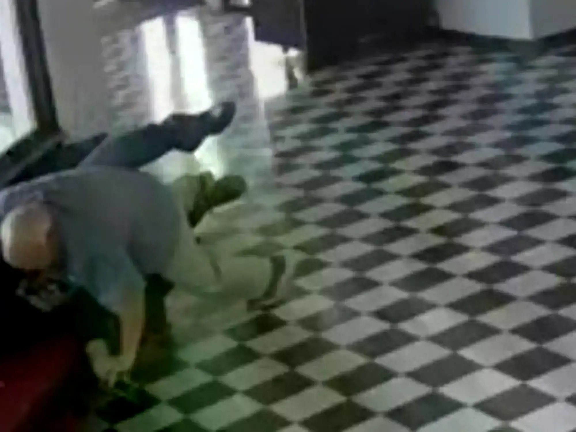 El director Kirk Moore forcejea con el agresor armado en el suelo del instituto.