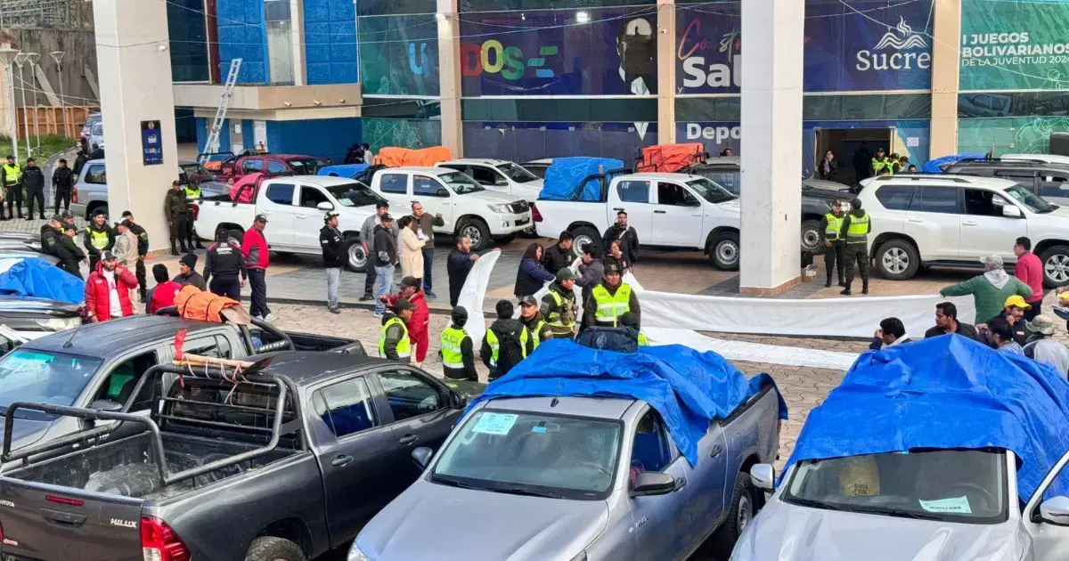 Vehículos trasladan maletas electorales desde un centro logístico.