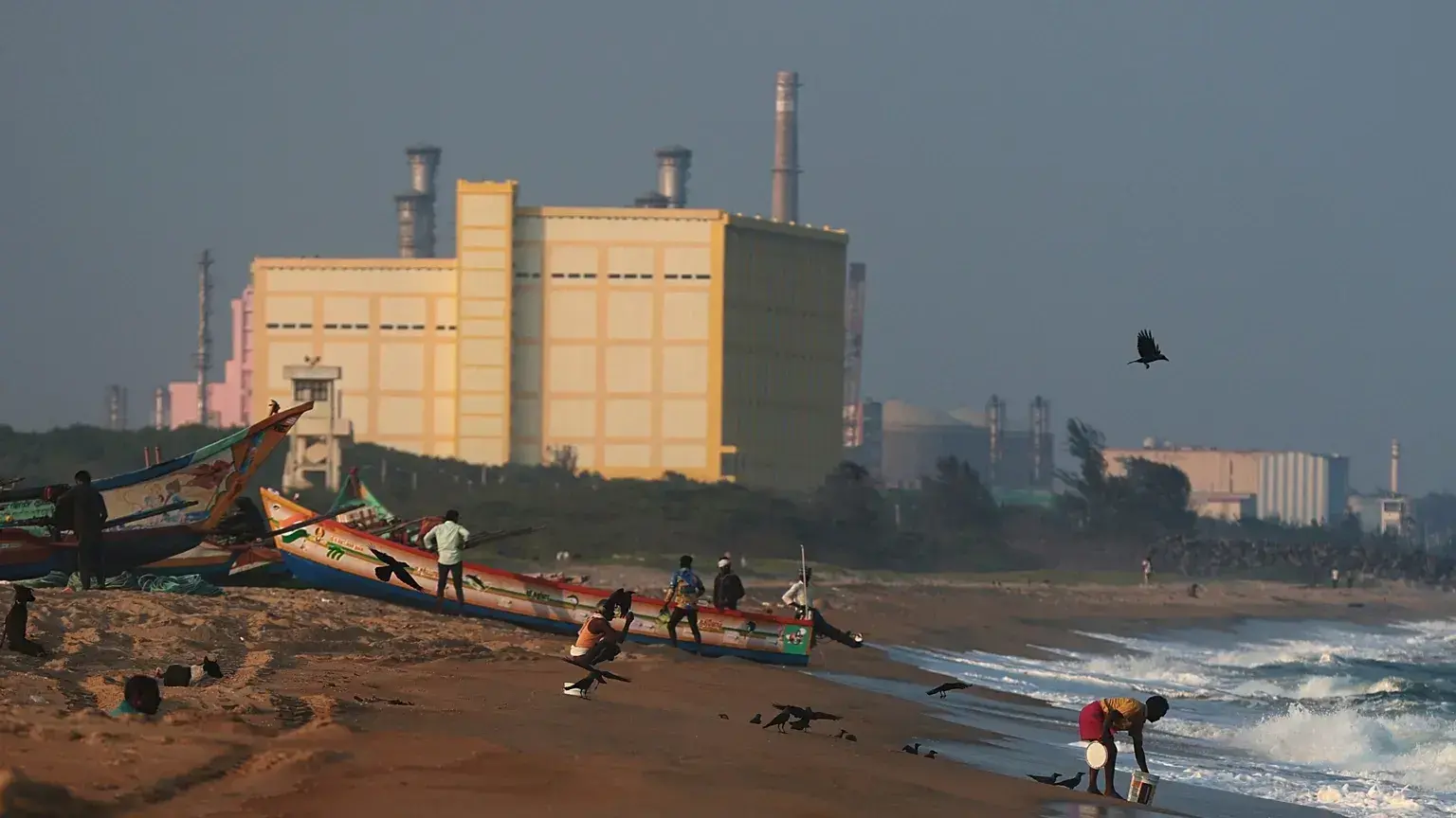 Unos pescadores amarran una barca cerca de la central nuclear Madras Atomic Power Station, en Kalpakkam, India.