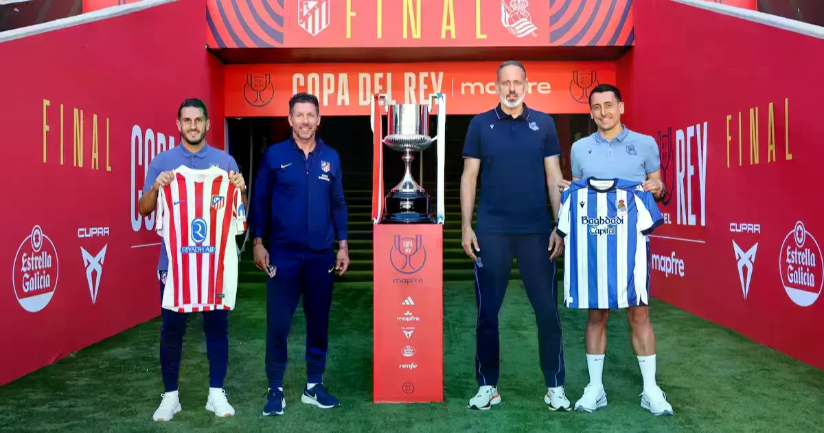 Los capitanes y entrenadores de ambos equipos con el trofeo.