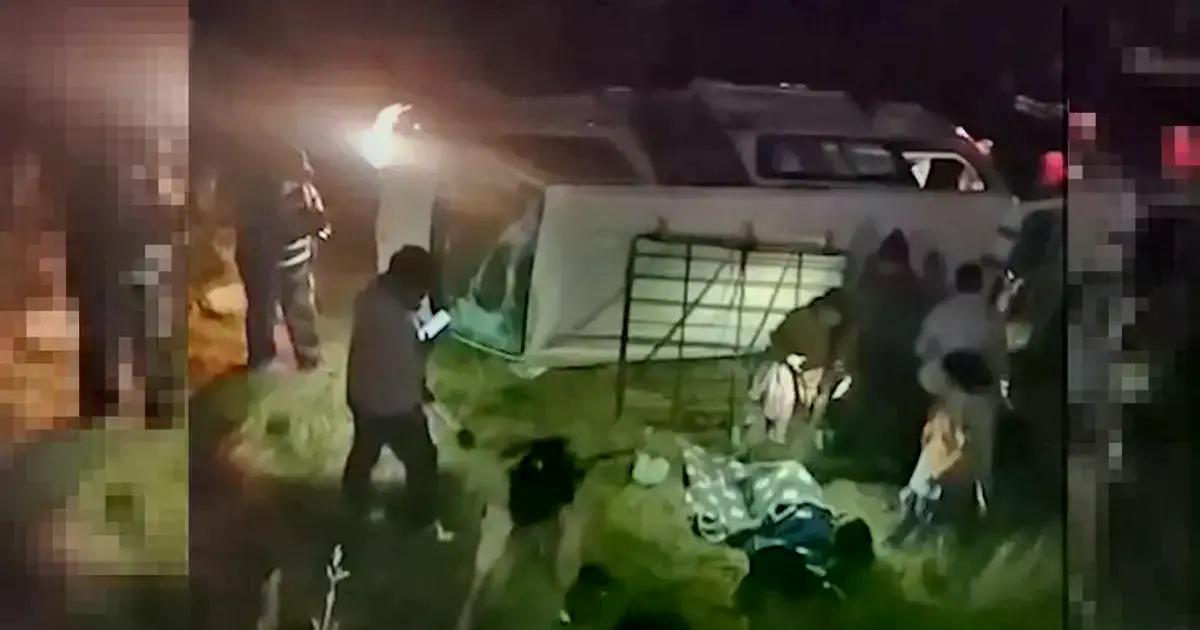 Minibús volcado a un lado de la vía.