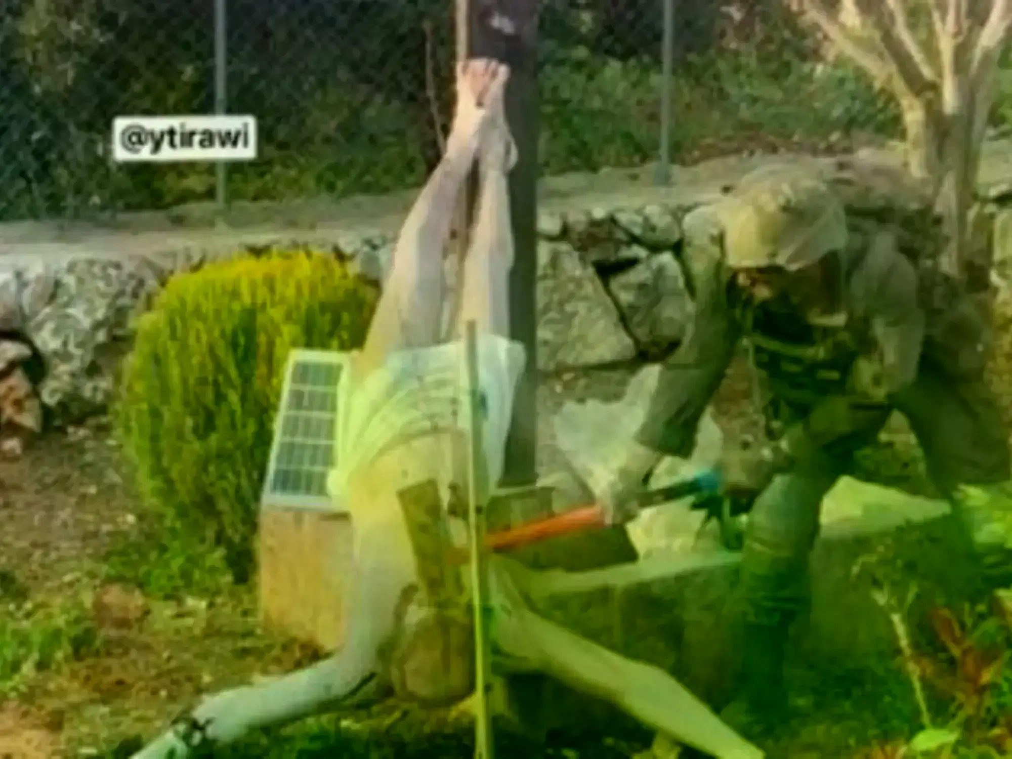 Soldado israelí destroza una figura de Cristo crucificado con un martillo.